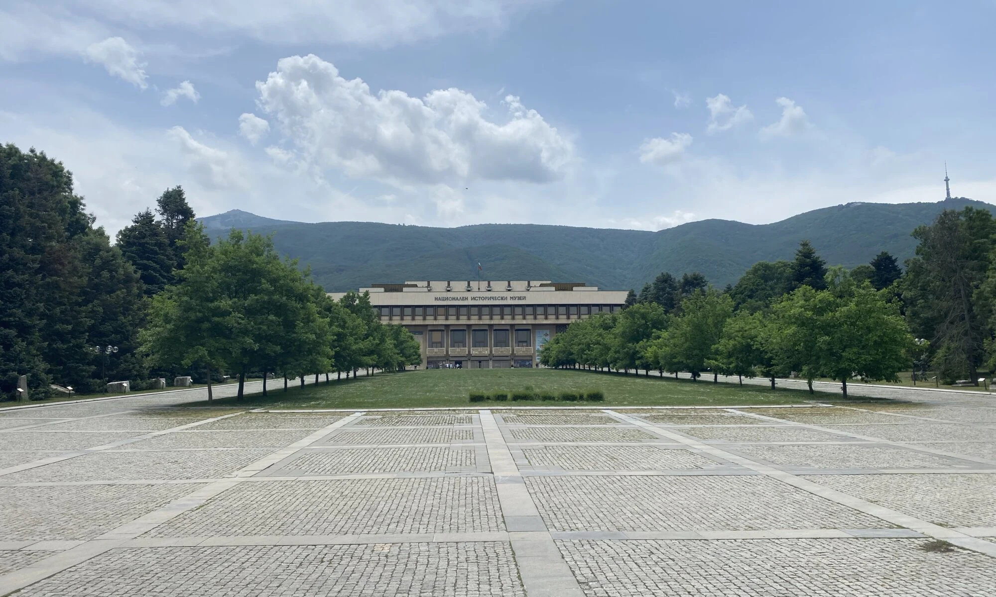 Bulgaria’s National History Museum in Sofia, seen across its tree-lined grounds with mountains behind it